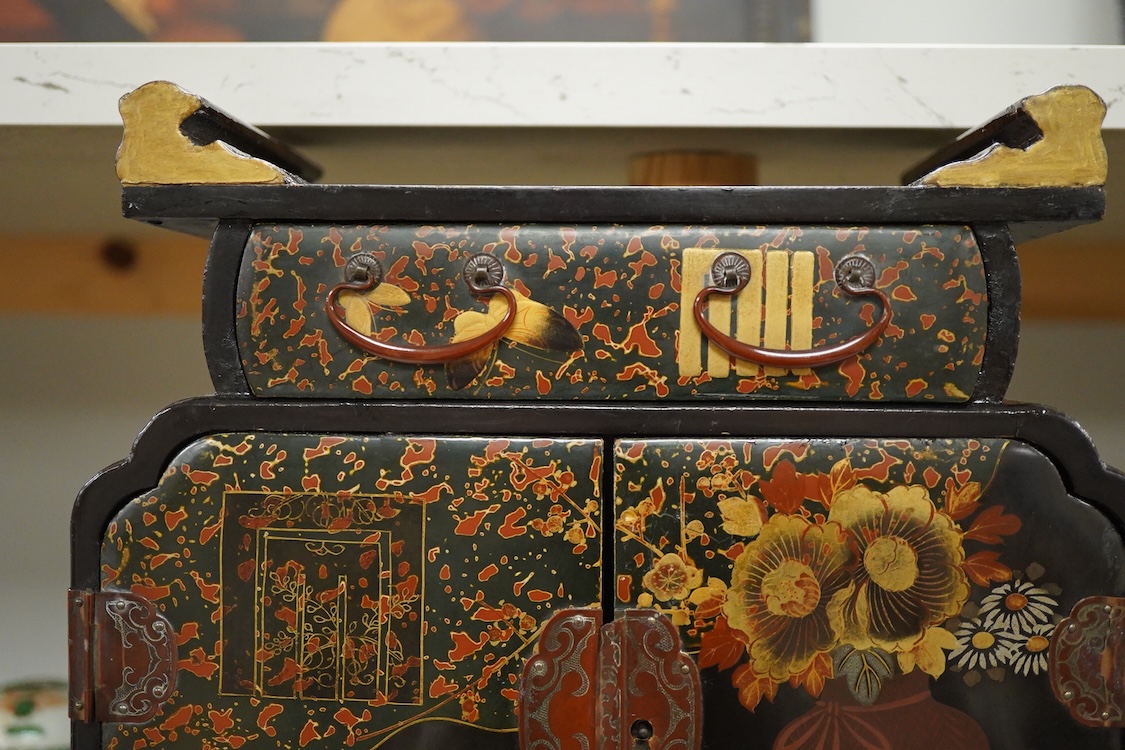A Japanese gilt decorated black lacquer table cabinet, fitted with seven drawers, with key, 35cm high